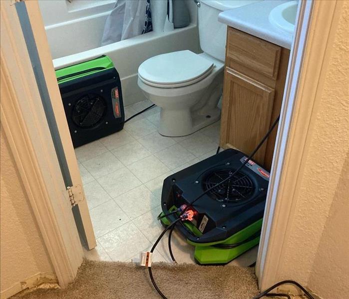 Air movers drying inside a bathroom.