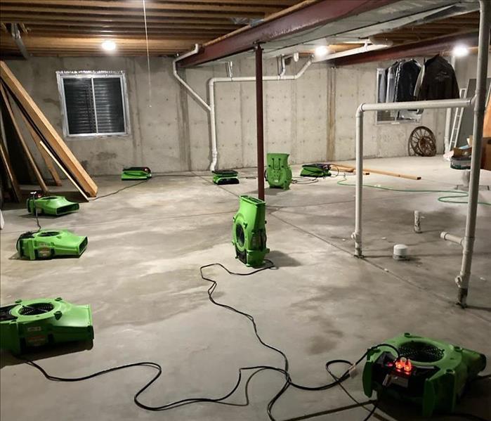 Many air movers on cement flooring.