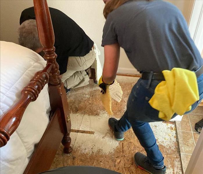 Two team members removing carpet.
